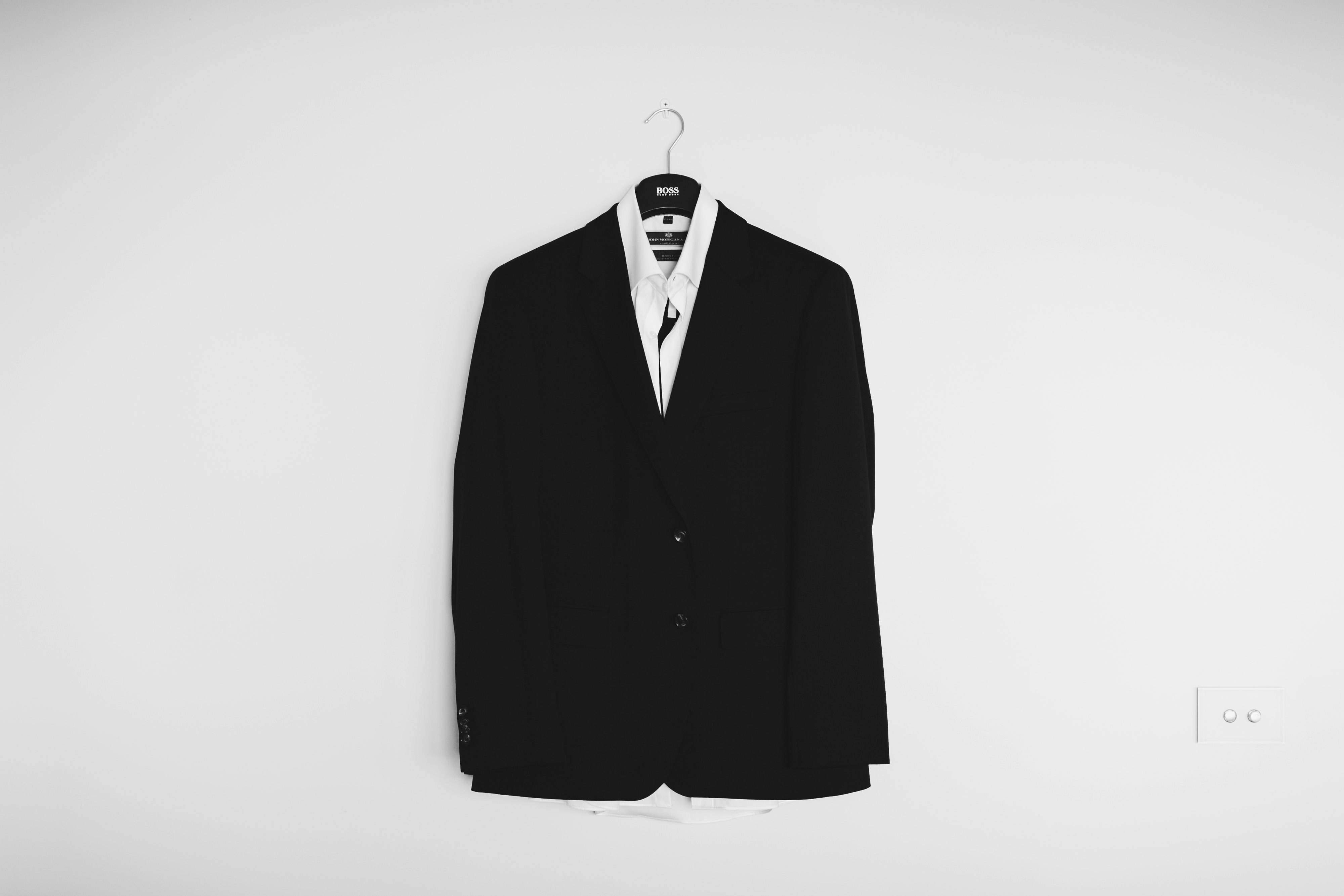 black suit jacket hanged on wall